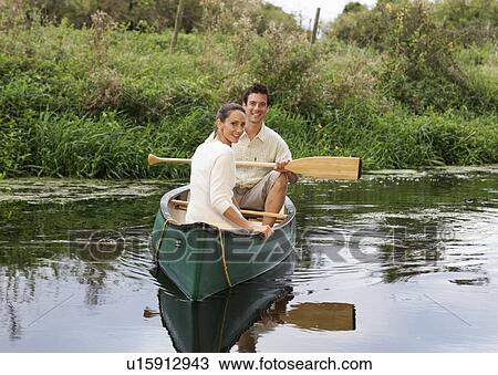 Stock Image - Young couple in a rowing boat. Fotosearch