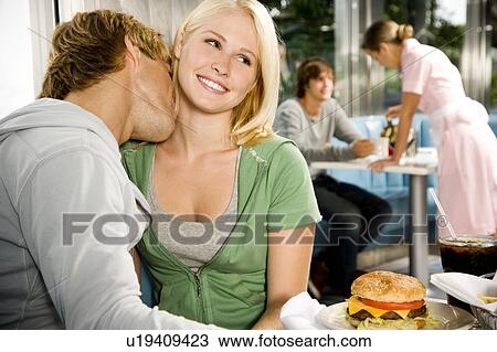 Young couple kissing, sitting in a diner View Large Photo Image Stock Image - Young couple kissing, sitting in a diner . Fotosearch