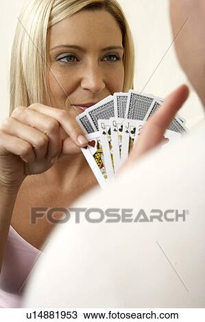 Stock Image - Young couple playing a game of cards, close-up. Fotosearch