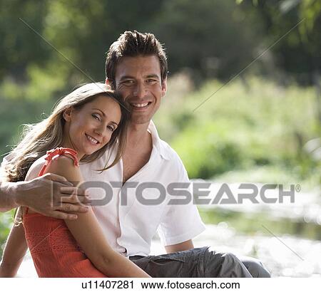 Stock Image - Young couple sitting in the sun. Fotosearch