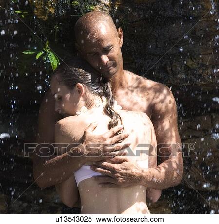 Young couple standing in a waterfall, embracing, close-up View Large Photo Image Stock Photography - Young couple standing in a waterfall, embracing, close-up. Fotosearch
