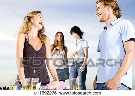 Young couple talking at a party View Large Photo Image Stock Photograph - Young couple talking at a party. Fotosearch