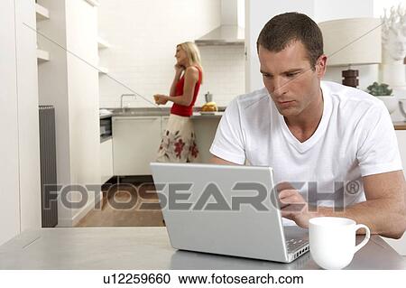 Stock Image - Young couple working from home. Fotosearch