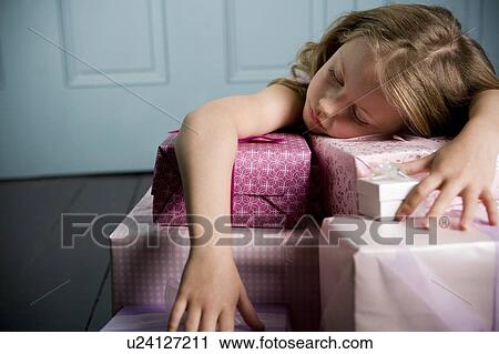 Young girl asleep and laying on her with birthday presents View Large Photo Image Stock Image - Young girl asleep and laying on her with birthday presents . Fotosearch