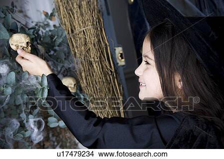 Picture - Young girl at the front door, dressed up as a witch for Halloween . Fotosearch