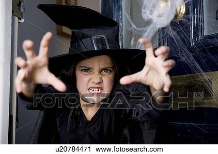 Young girl at the front door, dressed up as a witch for Halloween View Large Photo Image Stock Image - Young girl at the front door, dressed up as a witch for Halloween . Fotosearch