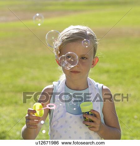 Young girl blowing bubbles View Large Photo Image Stock Photograph - Young girl blowing bubbles. Fotosearch