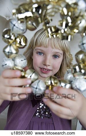 Young girl in a party dress, holding a Christmas decoration View Large Photo Image Stock Image - Young girl in a party dress, holding a Christmas decoration . Fotosearch