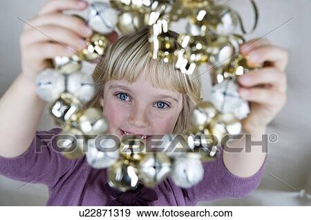 Young girl in a party dress, holding a Christmas decoration View Large Photo Image Stock Photo - Young girl in a party dress, holding a Christmas decoration . Fotosearch