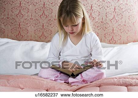 Young girl in her bedroom reading a book View Large Photo Image Stock Photo - Young girl in her bedroom reading a book . Fotosearch