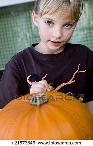 Stock Photograph - Young girl with a Halloween Pumpkin . Fotosearch