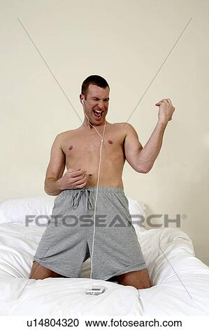 Young man in bed playing air guitar View Large Photo Image Stock Image - Young man in bed playing air guitar. Fotosearch