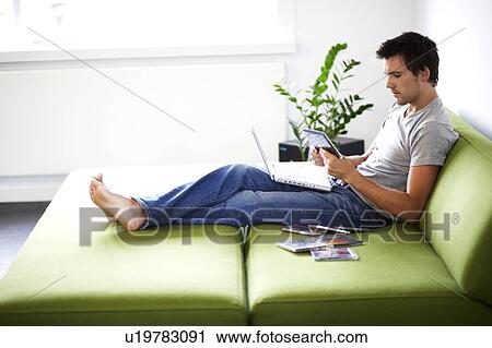 Young man looking at his CD collection View Large Photo Image Stock Image - Young man looking at his CD collection. Fotosearch