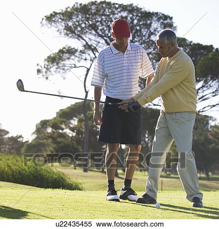 Stock Photography - Young man receiving golf lessons. Fotosearch