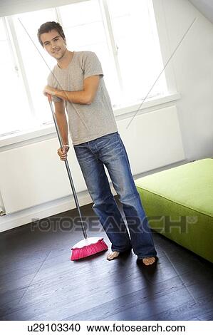 Young man sweeping the floor View Large Photo Image Stock Image - Young man sweeping the floor. Fotosearch