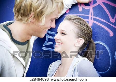 Stock Photograph - Young teenage couple in front of a graffiti covered wall. Fotosearch