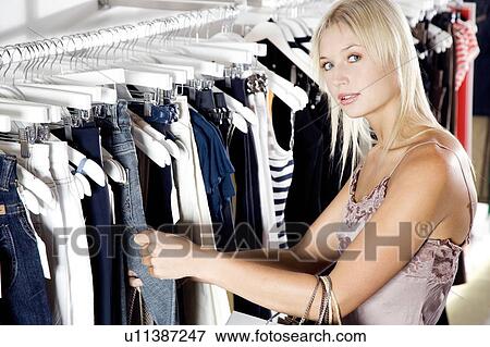 Young woman shopping for clothes View Large Photo Image Stock Photo - Young woman shopping for clothes. Fotosearch