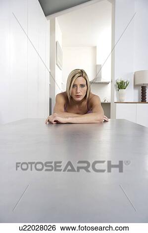 Stock Photograph - Young woman sitting at a table . Fotosearch