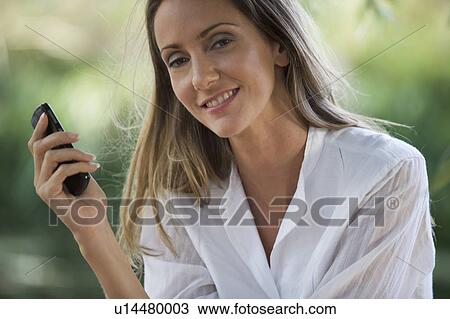 Stock Image - Young woman talking on a mobile phone. Fotosearch