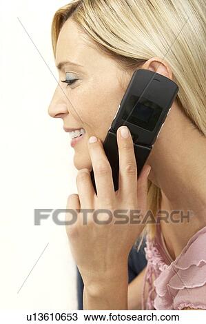 Stock Image - Young woman using a mobile phone, close-up. Fotosearch