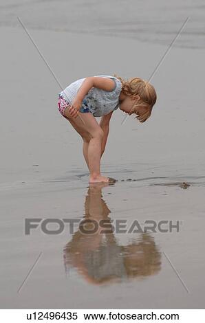 Stock Photography - 3 Year old playing in water on beach. Fotosearch