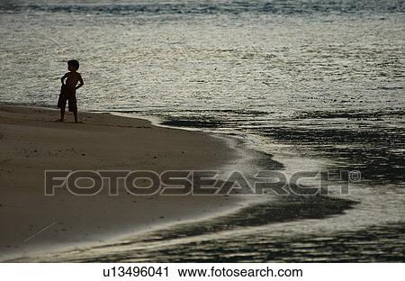 A young boy (6-8) standing on a beach View Large Photo Image Stock Image - A young boy (6-8) standing on a beach. Fotosearch