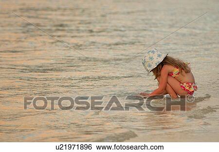 A young girl (6-8) playing in the sea View Large Photo Image Stock Photograph - A young girl (6-8) playing in the sea. Fotosearch