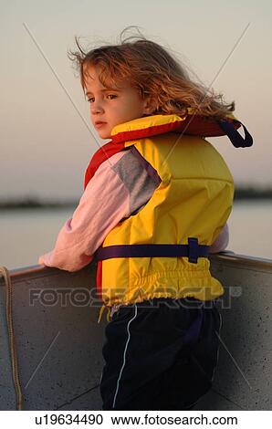 Stock Image - Blond girl in yellow lifejacket. Fotosearch