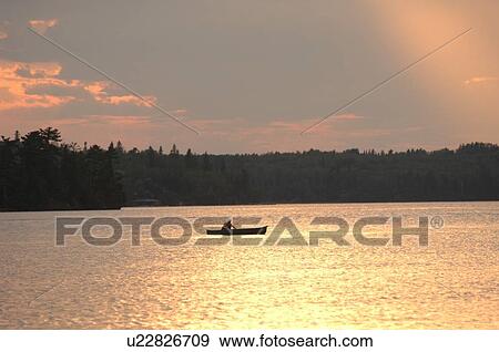 Boat on Lake of the Woods at twilight View Large Photo Image Stock Photo - Boat on Lake of the Woods at twilight. Fotosearch