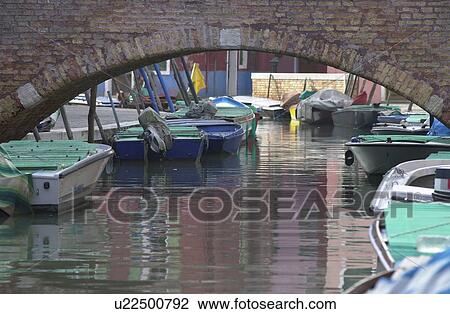 Stock Image - Boats in a canal in Venice, Burano, Italy. Fotosearch
