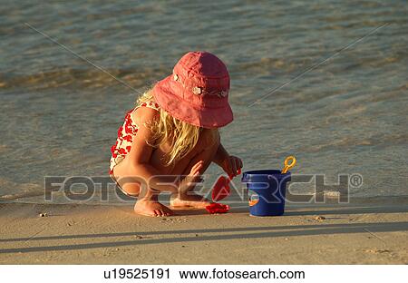 Close-up of a young girl (6-8) playing on a beach View Large Photo Image Stock Image - Close-up of a young girl (6-8) playing on a beach. Fotosearch