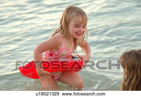 Close-up of a young girl (6-8) wearing a rubber tube in water View Large Photo Image Stock Photo - Close-up of a young girl (6-8) wearing a rubber tube in water. Fotosearch