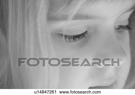 Stock Image - Close up of blond girl’s face in black & white. Fotosearch