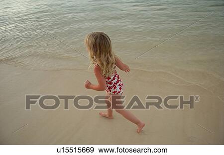 High angle view of a young girl running in water View Large Photo Image Stock Photo - High angle view of a young girl running in water. Fotosearch