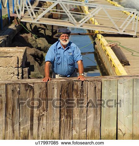 Stock Photography - Man standing on a pier in Prince Edward Island, Canada. Fotosearch