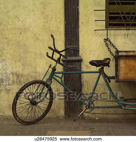 Stock Photography - Pedicab chained to a window railing. Fotosearch
