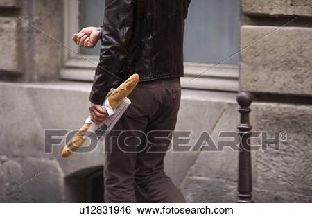 Person carrying a loaf of French bread in Paris, France View Large Photo Image Stock Photograph - Person carrying a loaf of French bread in Paris, France. Fotosearch