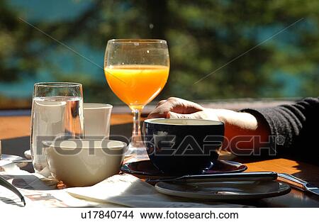 Picture - Person sitting at a breakfast table, Rocky Mountains, Canada. Fotosearch