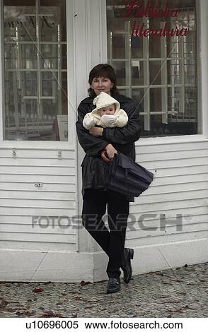 Portrait of young woman standing holding a baby in Prague View Large Photo Image Stock Photography - Portrait of young woman standing holding a baby in Prague. Fotosearch