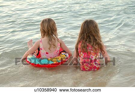 Stock Image - Rear of two young girls. Fotosearch