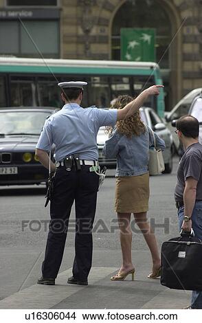 Picture - Rear view of a policeman directing traffic in Paris, France. Fotosearch