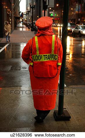 Stock Photograph - Rear view of a traffic personnel standing on the sidewalk. Fotosearch