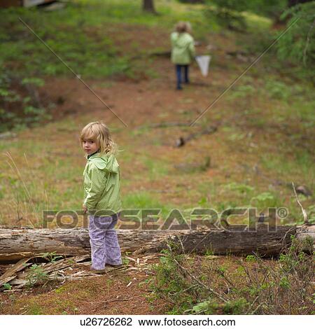 Rear view of two young girls in the woods with a butterfly net View Large Photo Image Stock Image - Rear view of two young girls in the woods with a butterfly net. Fotosearch