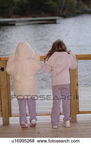 Stock Photo - Two children looking over railing. Fotosearch
