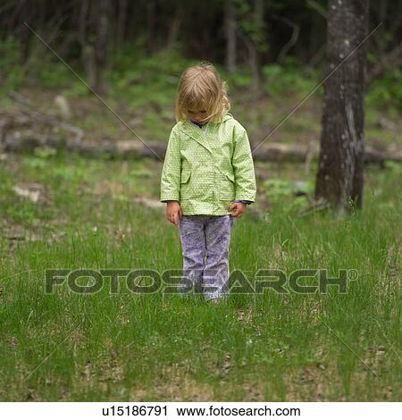 Young girl standing in the woods looking down View Large Photo Image Stock Image - Young girl standing in the woods looking down. Fotosearch