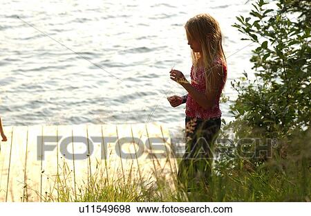 Young girl standing on a wooden platform View Large Photo Image Stock Photo - Young girl standing on a wooden platform. Fotosearch