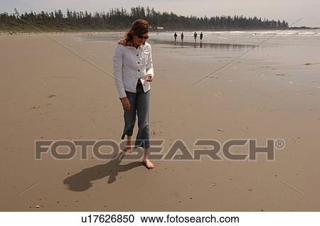 Stock Image - Young girl walking on beach, Pacific Rim National Park, Vancouver Island, Canada. Fotosearch