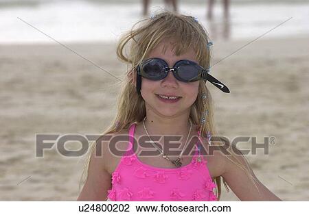 Young girl wearing goggles standing on the beach View Large Photo Image Stock Image - Young girl wearing goggles standing on the beach. Fotosearch