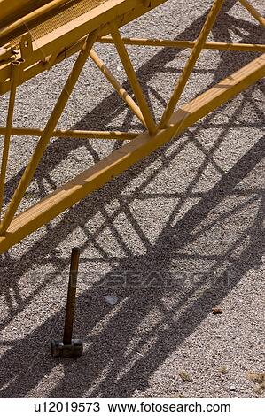 Aerial detail view of crane boom on ground, with hammer propped in foreground View Large Photo Image Stock Image - Aerial detail view of crane boom on ground, with hammer propped in foreground . Fotosearch