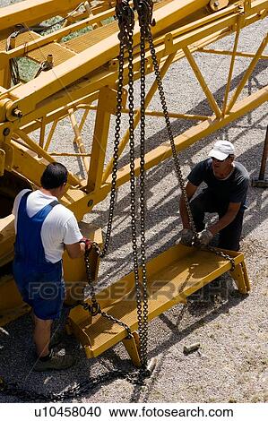 aerial view of men assembling crane boom with chains for lifting from ground View Large Photo Image Stock Image - aerial view of men assembling crane boom with chains for lifting from ground . Fotosearch